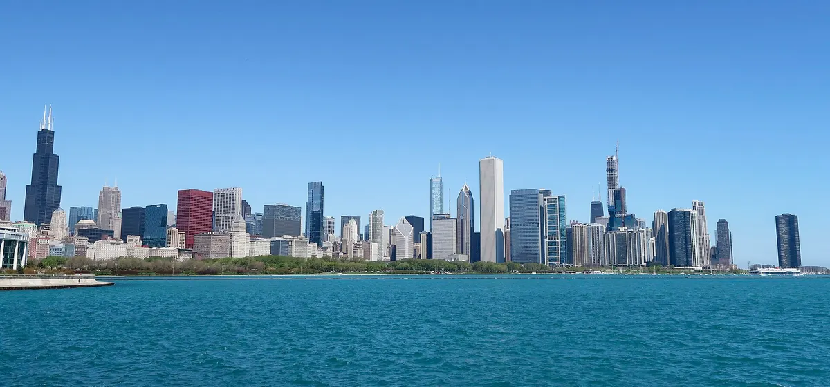 Downtown Chicago's skyline across the blue water of Lake Michigan under a clear sky, seen from Northerly Island