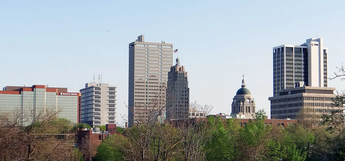 Downtown Fort Wayne's towers and the domed Allen County Courthouse above spring trees