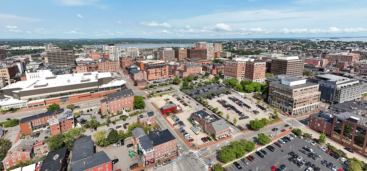 Aerial view of downtown Portland's brick buildings and streets, with open water and islands beyond