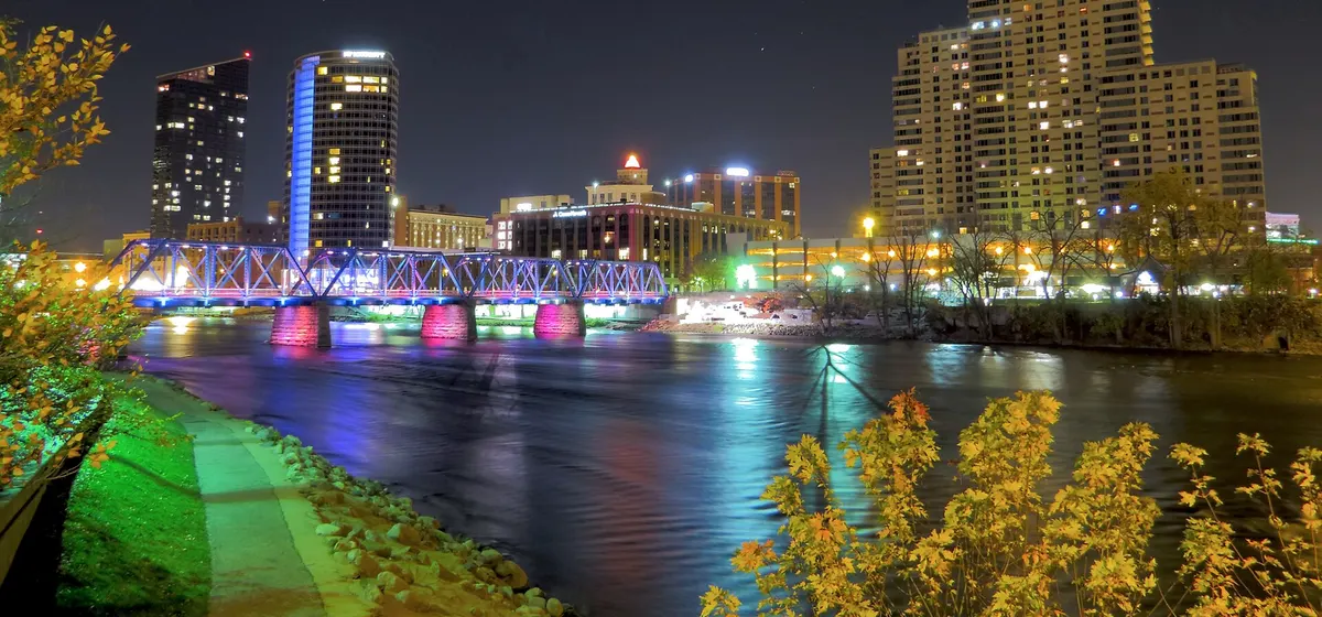 Downtown Grand Rapids' towers and the lit Blue Bridge over the Grand River at night