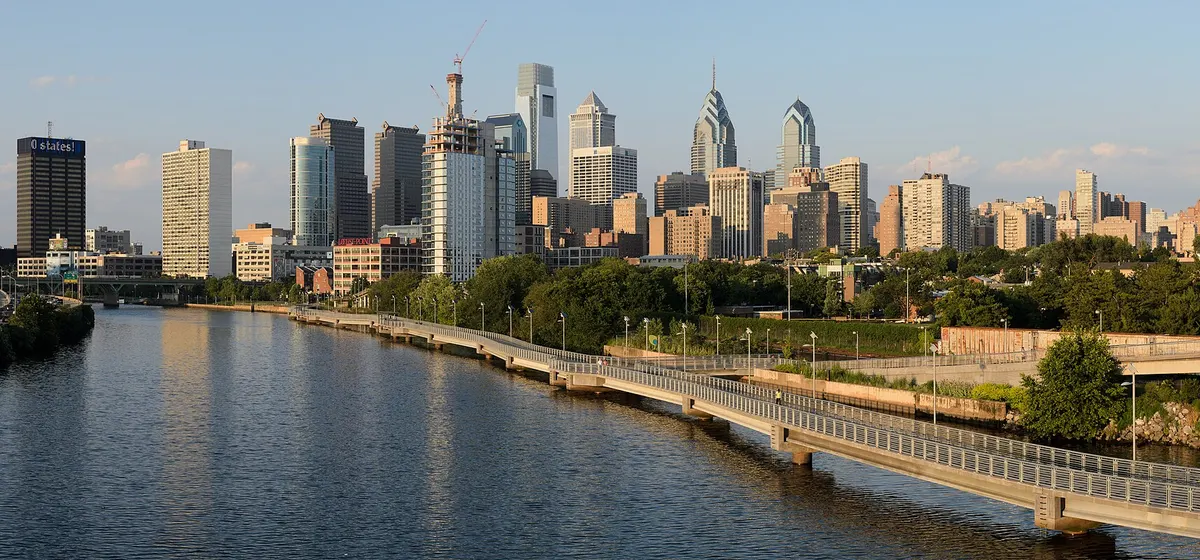 Center City Philadelphia's towers at dusk above the Schuylkill River and its riverside trail