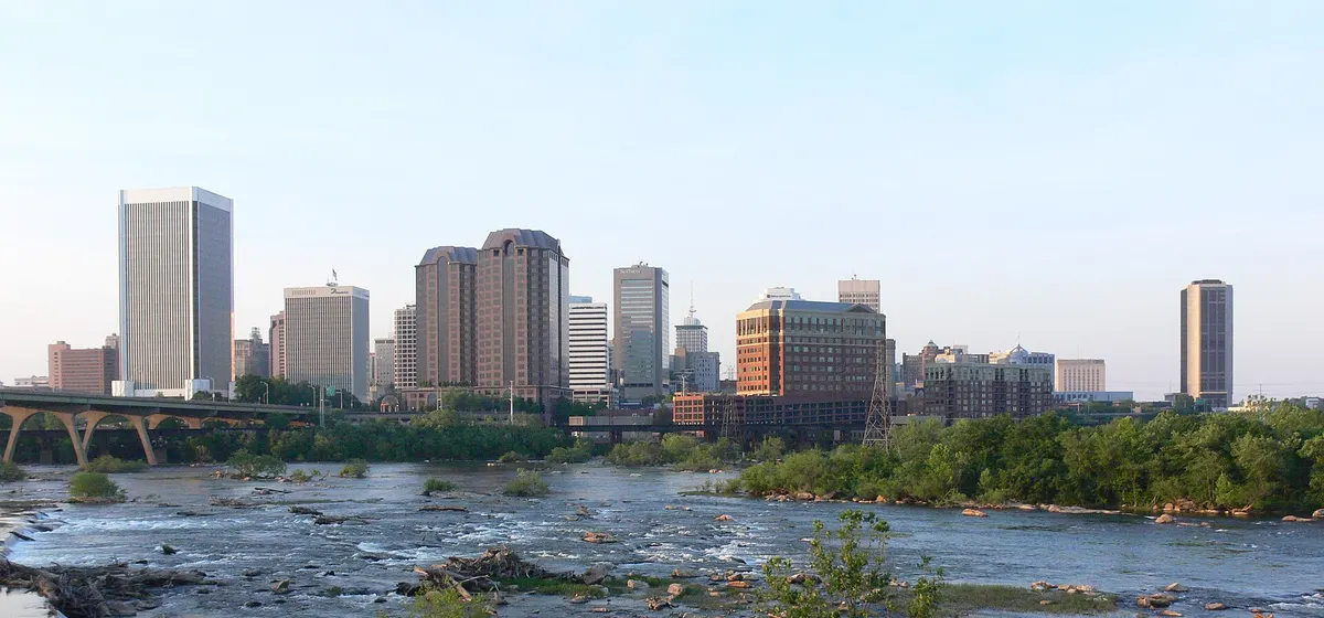 Downtown Richmond's office towers beyond the rocky rapids of the James River in evening light